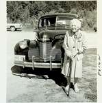 Photograph of Woman in front of vehicle