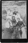 Outside portrait of a group of women, and one man, against a rocky background.