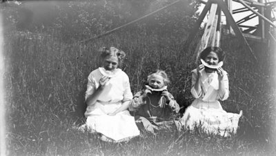 Middle Island:  Esther Hartlep (middle) with two unidentified girls eating watermelon in summer.