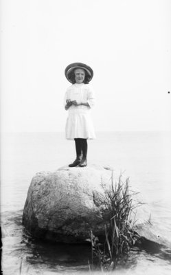 Middle Island:  Esther Hartlep standing on big rock near shore of Lake Huron.