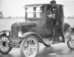 Michigan State Police Trooper checking a driver and automobile, c 1920s