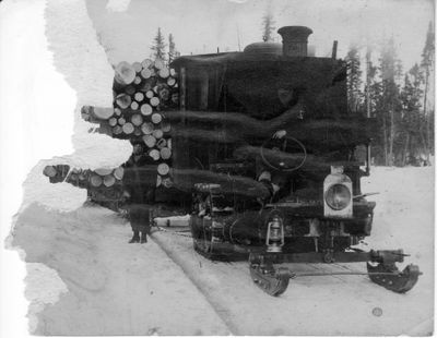 045 Two men with sleigh tractor with load of logs in woods