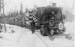 061 Two men with snow tractor hauler with several sleigh beds loaded with logs