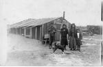 237 Native American family in front of lumber camp building.