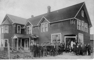 455 Large group of mostly men standing outside a large home (boarding house?)