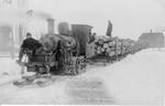 628 Sled steam train pulling open cars of logs on ice trail.