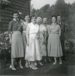 Eight people standing in front of a Clapboard house
mid 1950s