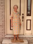 Ruby Herrington in a pastel plaid dress standing outside at the front door.