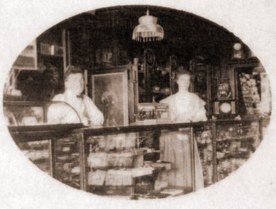 Shop keepers - A couple behind the counter at W.W. Porte's store located at 5 Main Street, Brighton, Ontario in 1895.