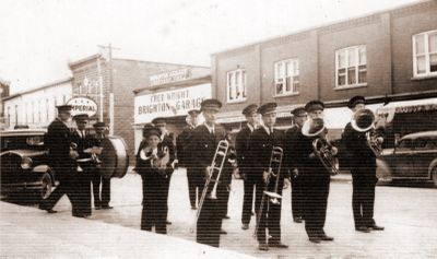 A brass band on Main Street in front of Fred Wright's garage in downtown Brighton, Ontario.