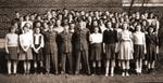 A large group of students with three men in uniform.