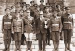 Military stands on steps with trophy