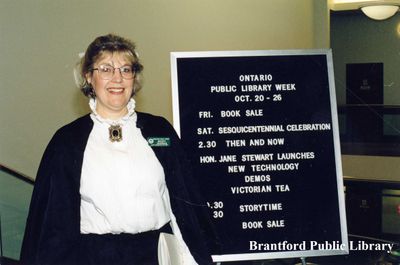 Wendy Newman Beside the Schedule of Events for the City of Brantford Sesquicentennial Celebrations at the Brantford Public Library