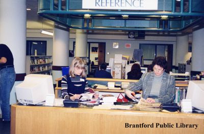 Two Brantford Public Library Staff Members at the Main Branch Reference Desk