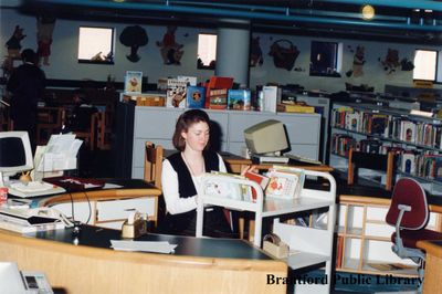 Brantford Public Library Staff Member Sorts Through Books at a Library Desk