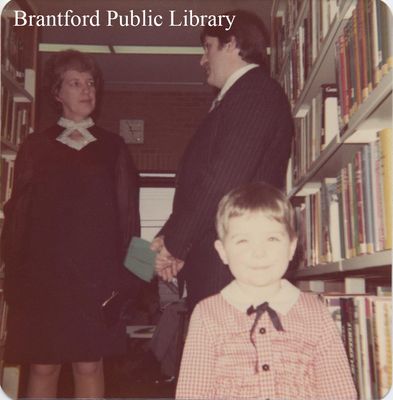 Two People Speak Behind a Smiling Child in the St. Paul Branch of the Brantford Public Library, Undated