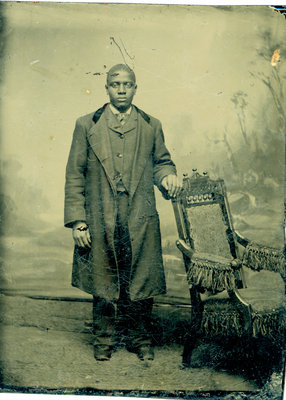 Tintype of African American Man in Topcoat Standing with Chair [n.d.]