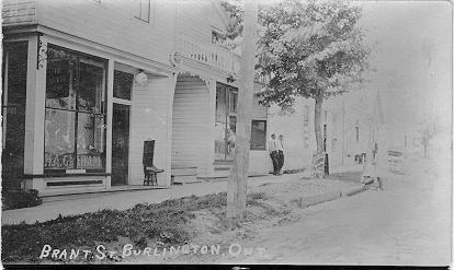Brant St., Burlington, Ont -- view of H.A. Graham store in foreground, two men standing in middleground