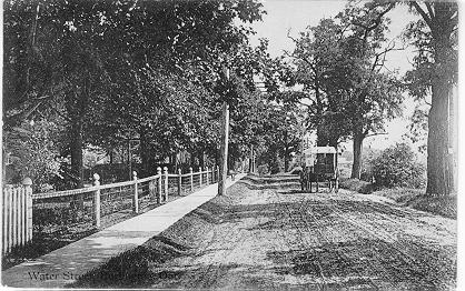 Water Street, Burlington, Ont. -- view of car driving along fenced road; postmarked August 25, 1913