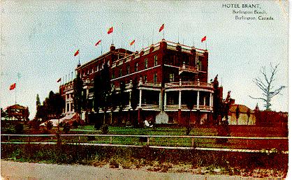 Hotel Brant, Burlington Beach, Burlington, Canada -- Exterior, east end with flags; postmarked May 18, 1910