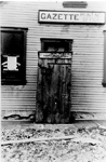 An outhouse set in front of the door to the Gazette Printing Office, now 370 Brant Street, as a Hallowe'en prank, ca 1910
