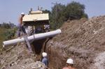 Installing underground pipe, 1970