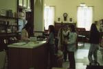 Interior of Carnegie library, checkout desk and reference department, 1973