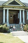 Exterior of Carnegie library, patrons on front steps, 1973