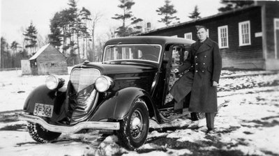 Militaire (Raymond Laporte) devant une voiture