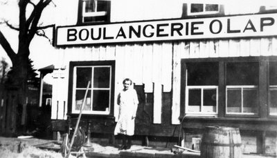 Mme Oscar Laporte, devant la boulangerie.