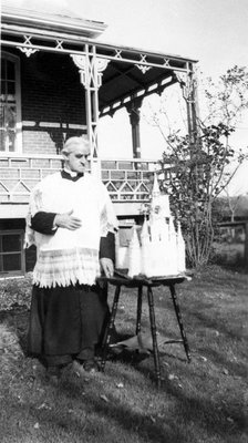 Le Curé Forget devant le gâteau de son 50e anniversaire de prêtrise.