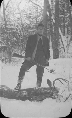 Full-length portrait of a hunter with a slain stag at this feet