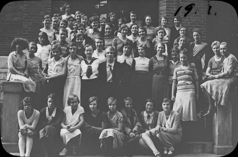 Portrait of a group of young women on the steps of Colborne High School, 1920s[?]