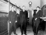 Three bank employees standing inside a bank, Colborne