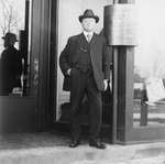 Scougale of Scougale Brothers Ladies Wear standing on the steps of his storefront, Colborne