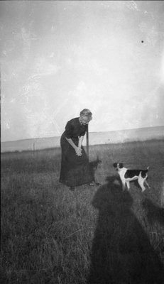 Woman standing in a field with her dog