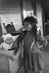 Young girl with a baby in a carriage on the porch of the Griffis' summer house