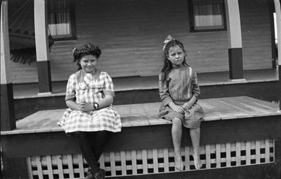 Two young girls sitting on Griffis' summer house porch