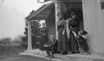 Three women, a man and a dog on a porch