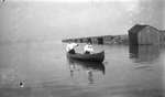 Man paddling a canoe with a woman companion at the bow