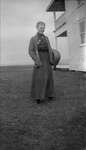 Woman holding a basket outside of a home