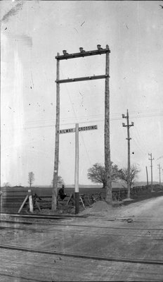 Man sitting on a fence at a railway crossing