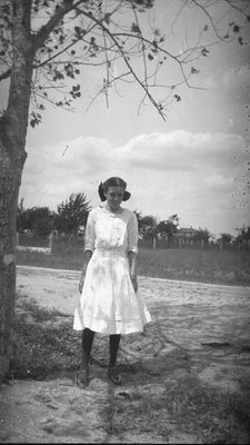 A girl standing under a tree