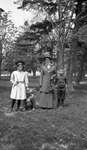 A woman with two children and a dog in a park