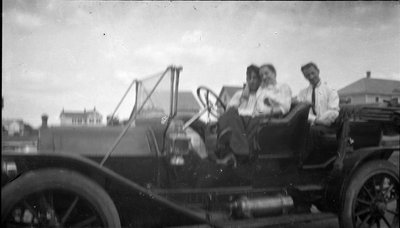 Three people in a 1910s car