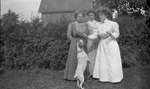 Three women and a dog in a backyard