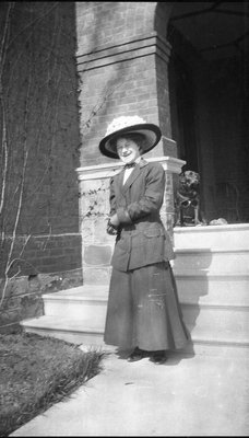 A woman with her dog standing in front of an entrance to a house