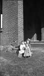 Three little girls in front of a brick house