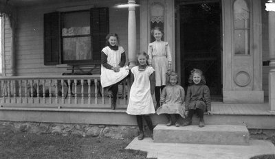 Five young girls in front of a house