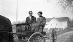 A young couple in a horse drawn carriage
